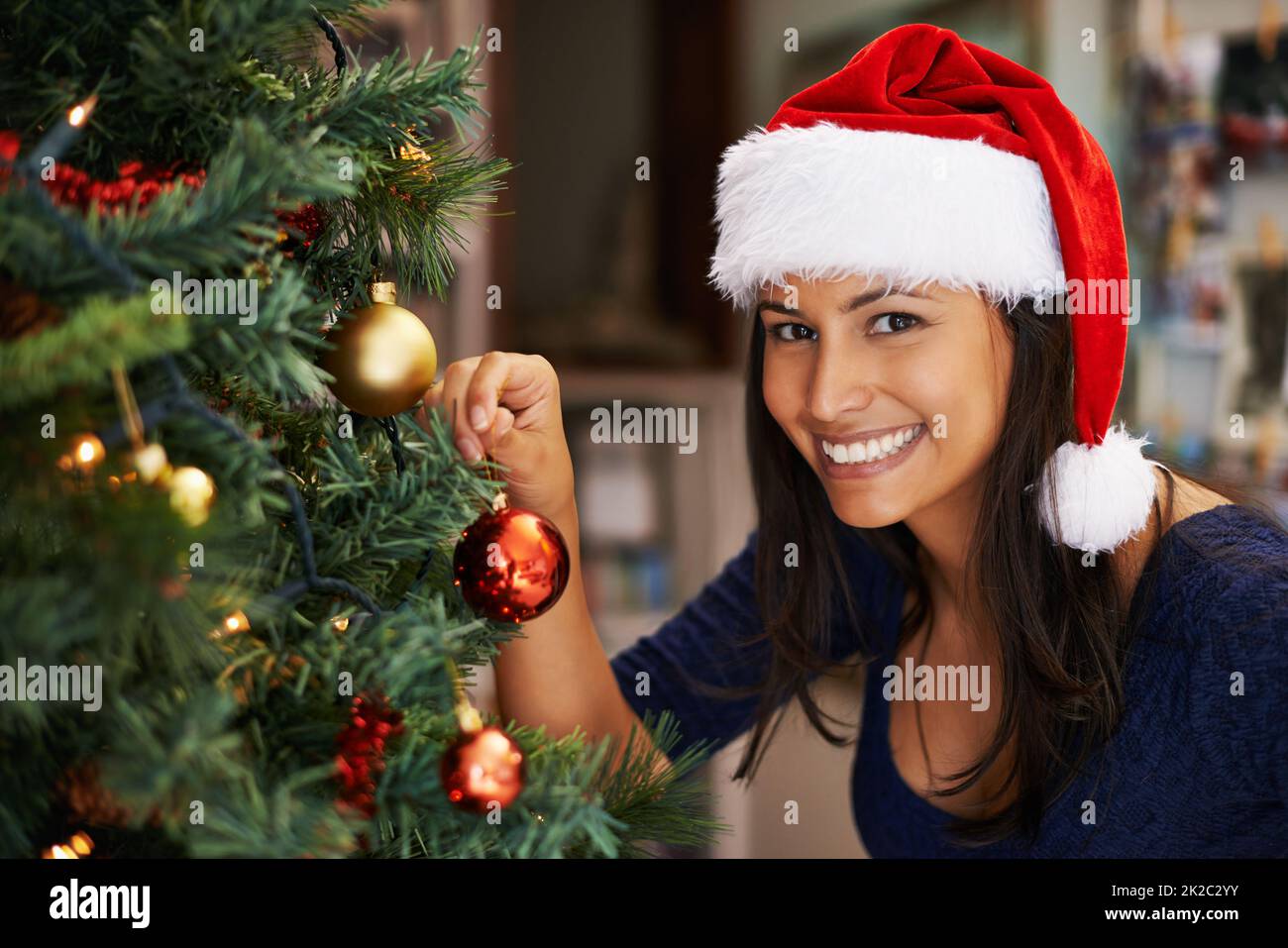 Shes un pro alla decorazione dell'albero di Natale. Ritratto di una bella giovane donna che decora un albero di Natale. Foto Stock