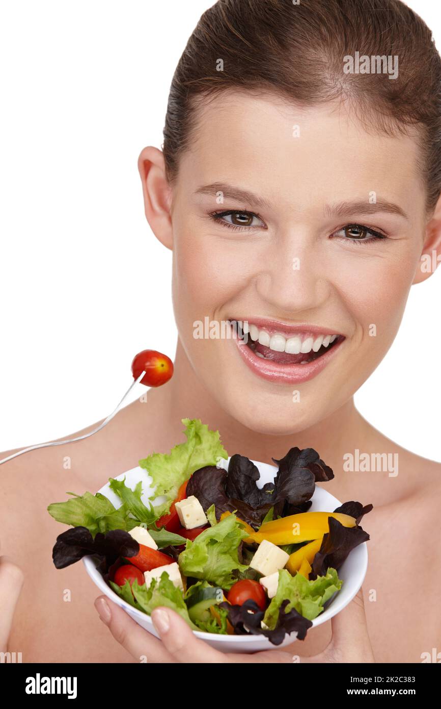 Mi piace l'insalata... REALE. Primo piano di una ragazza adolescente che tiene una ciotola di insalata sana. Foto Stock