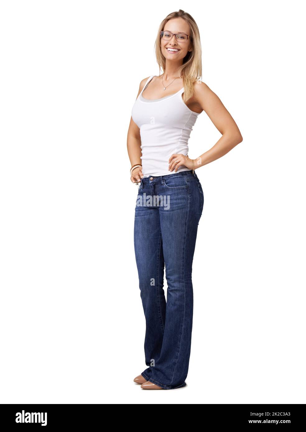 Incandescente con sicurezza. Giovane donna fiduciosa in jeans blu in piedi con le mani sui fianchi. Foto Stock