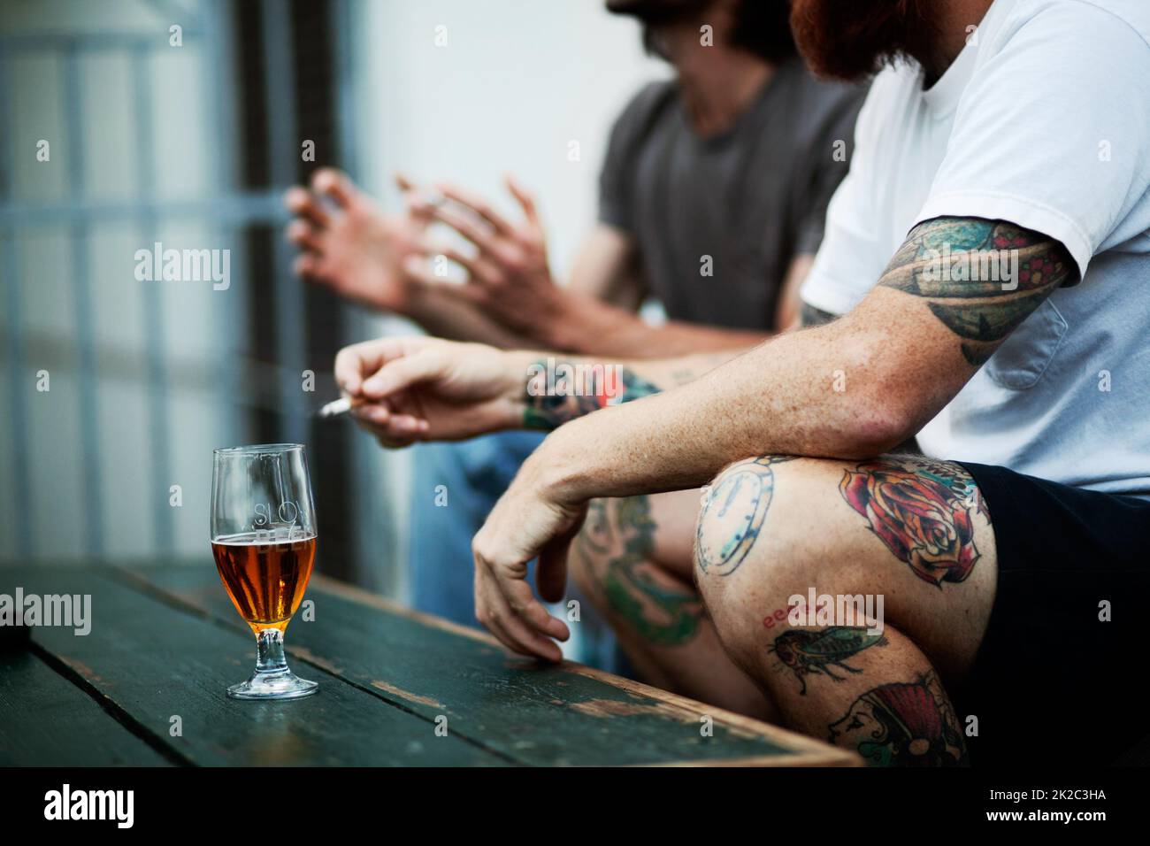 Estate tempo socializzante. Shot di giovani che fumano e bevono. Foto Stock