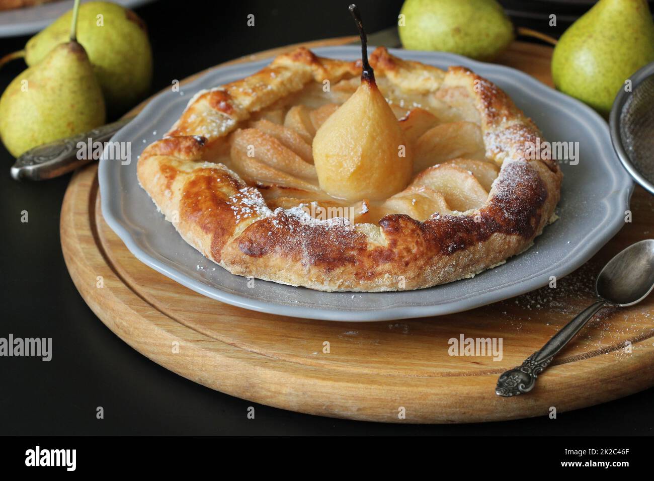 In casa galette con pere su sfondo nero. Cucina francese - Breton galette. Dolce torta aperto Foto Stock