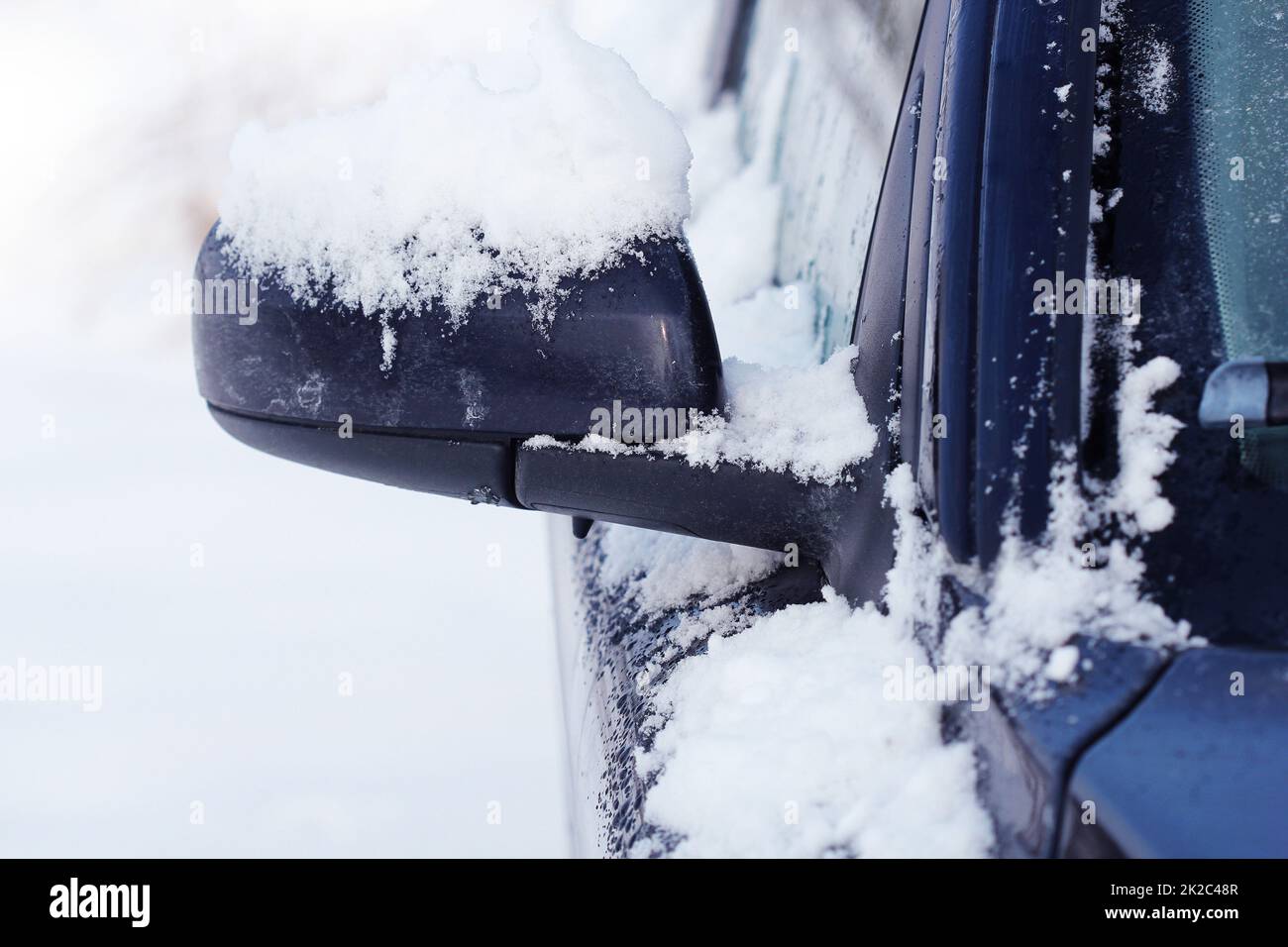 Specchietto laterale di auto coperto di neve in inverno vicino fino Foto Stock