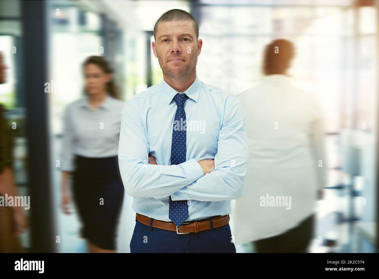 Il successo è qualcosa che dovete mantenere in movimento. Ritratto di un uomo d'affari maturo in piedi in un ufficio occupato. Foto Stock