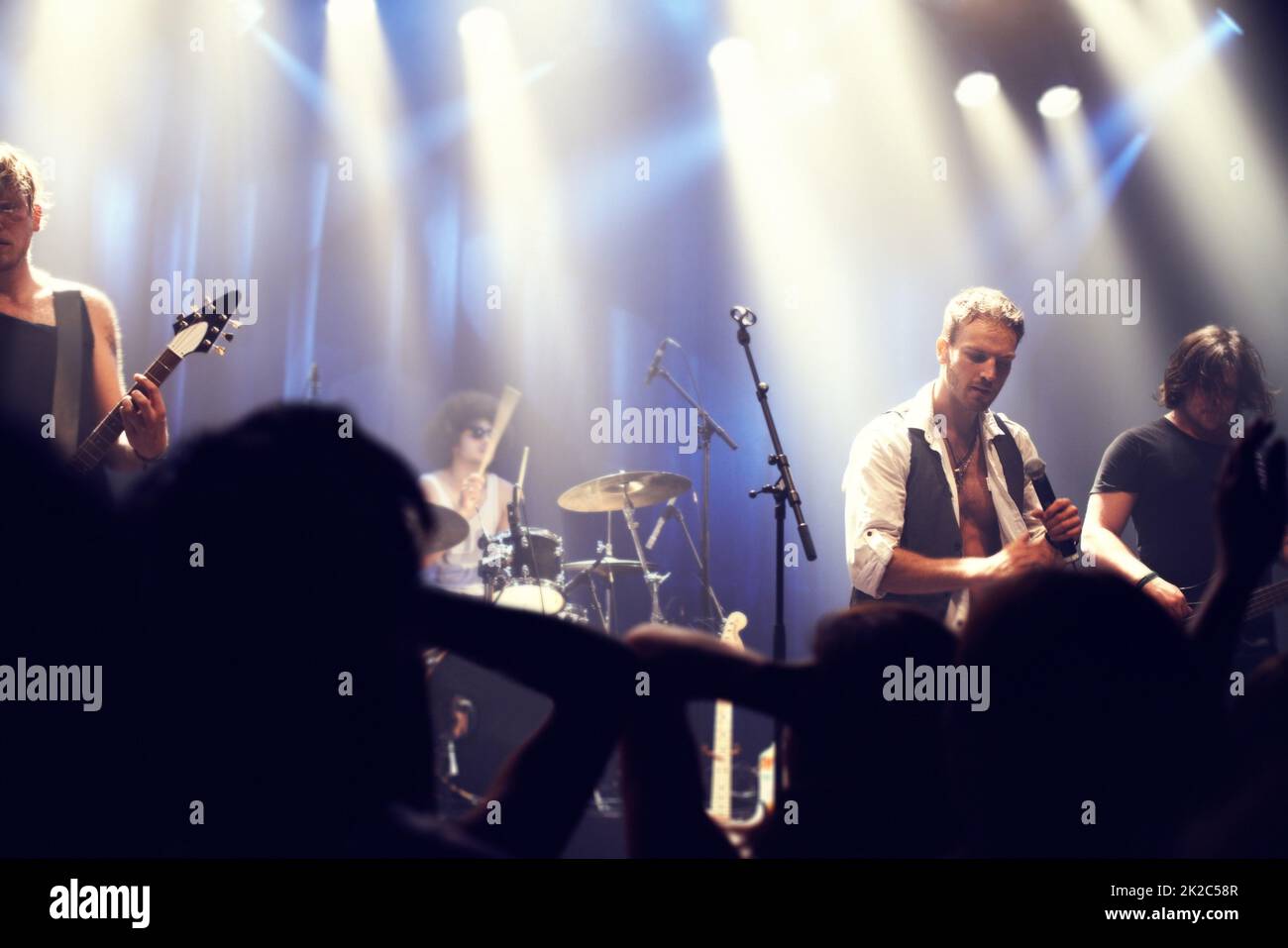 Ripresa ritagliata di un chitarrista sul palco circondato da fan adoranti. Questo concerto è stato creato per l'unico scopo di questo servizio fotografico, con 300 modelli e 3 band dal vivo. Tutte le persone in questo sparo sono modello rilasciato. Foto Stock