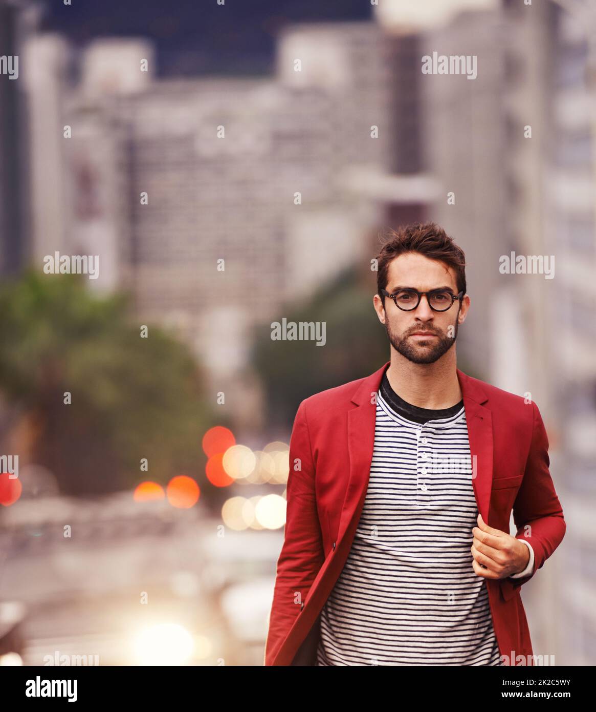 Camminare per le strade con stile. Scatto di un bel giovane uomo che fa una passeggiata attraverso la città. Foto Stock