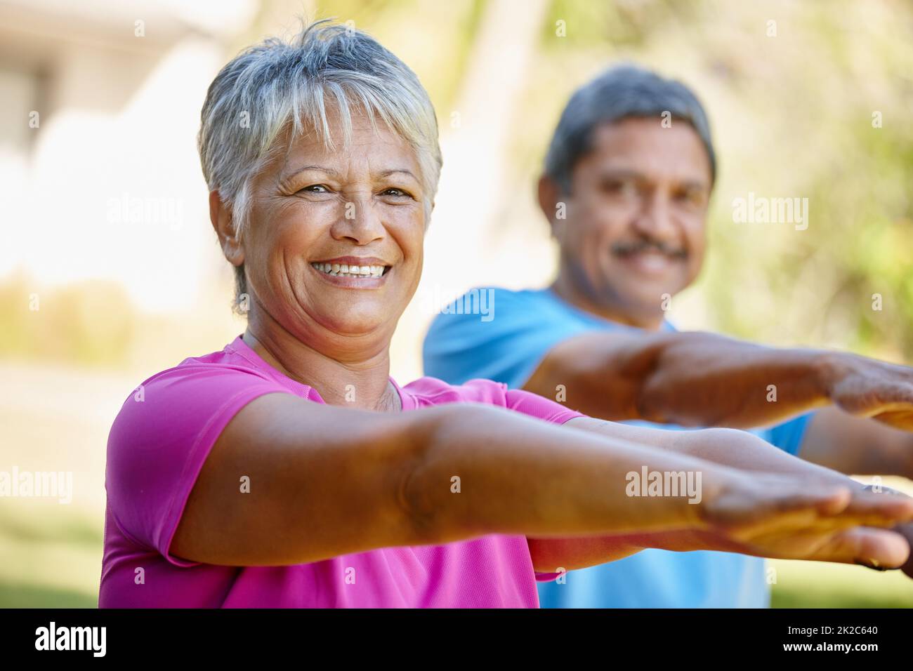 Vivere la vita con vitalità. Ritratto di una coppia matura esercitandosi insieme nel loro cortile. Foto Stock