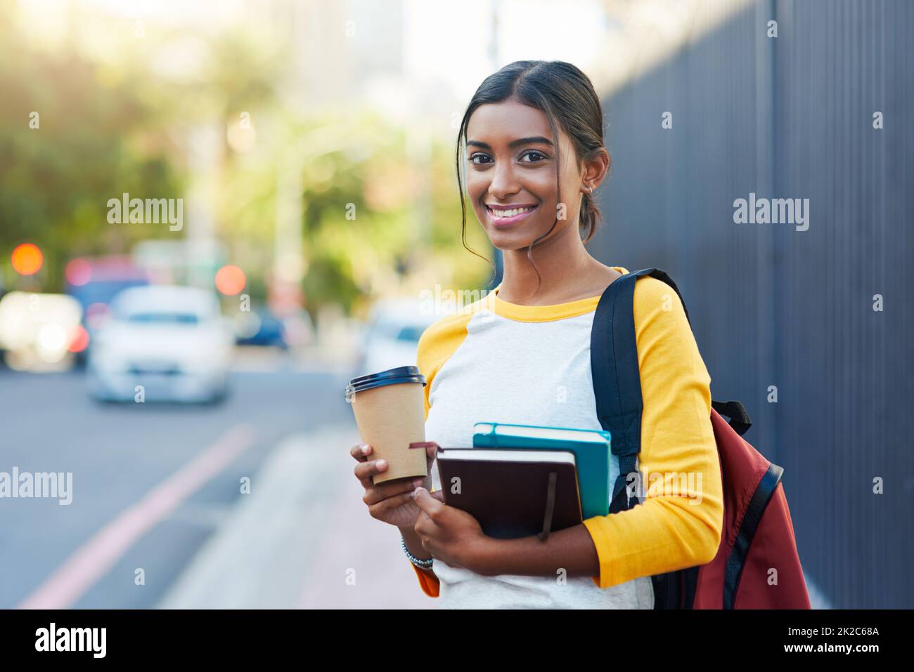 Ive ha ottenuto i miei libri e caffè, im pronto per l'università. Scatto corto di una giovane studentessa femminile che commuta all'università in città. Foto Stock