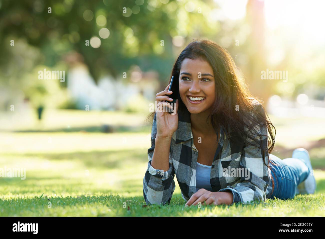 Im in attesa nel parco. Scatto di una giovane donna attraente che parla al telefono in un parco. Foto Stock