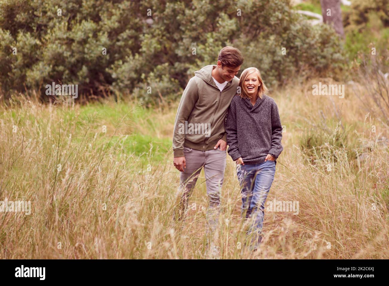 Il matrimonio può essere una passeggiata nel parco. Una giovane coppia ridendo come la passeggiata in un campo. Foto Stock