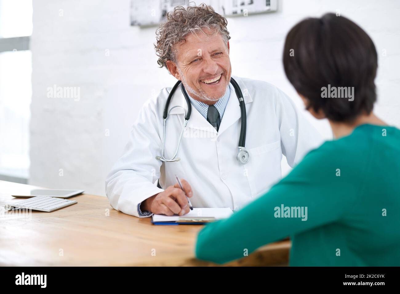 HES ha ottenuto un modo meraviglioso del comodino. Shot di un medico maturo sorridente che ha una consultazione con un paziente. Foto Stock