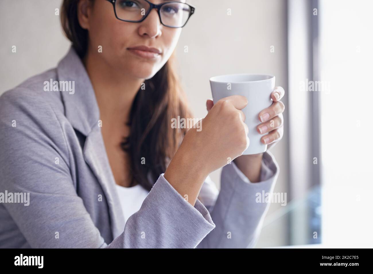 Caffè - opera su 3 tazze al giorno. Ritratto corto di una donna d'affari attraente in una pausa caffè. Foto Stock