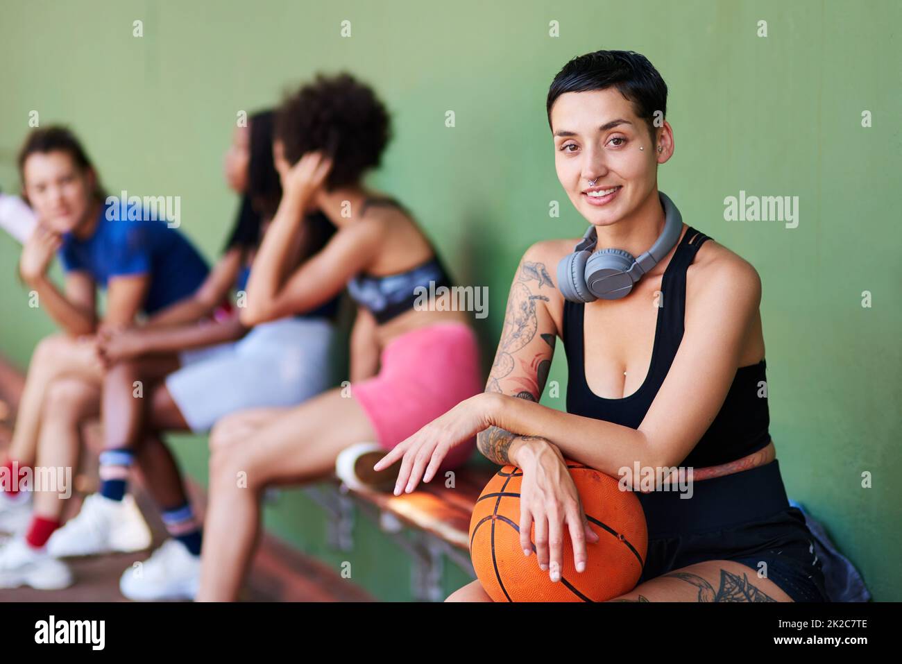 Gioca sempre con tutto il tuo cuore. Ritratto di una giovane donna sportiva che fa una pausa con i suoi amici dopo una partita di basket. Foto Stock