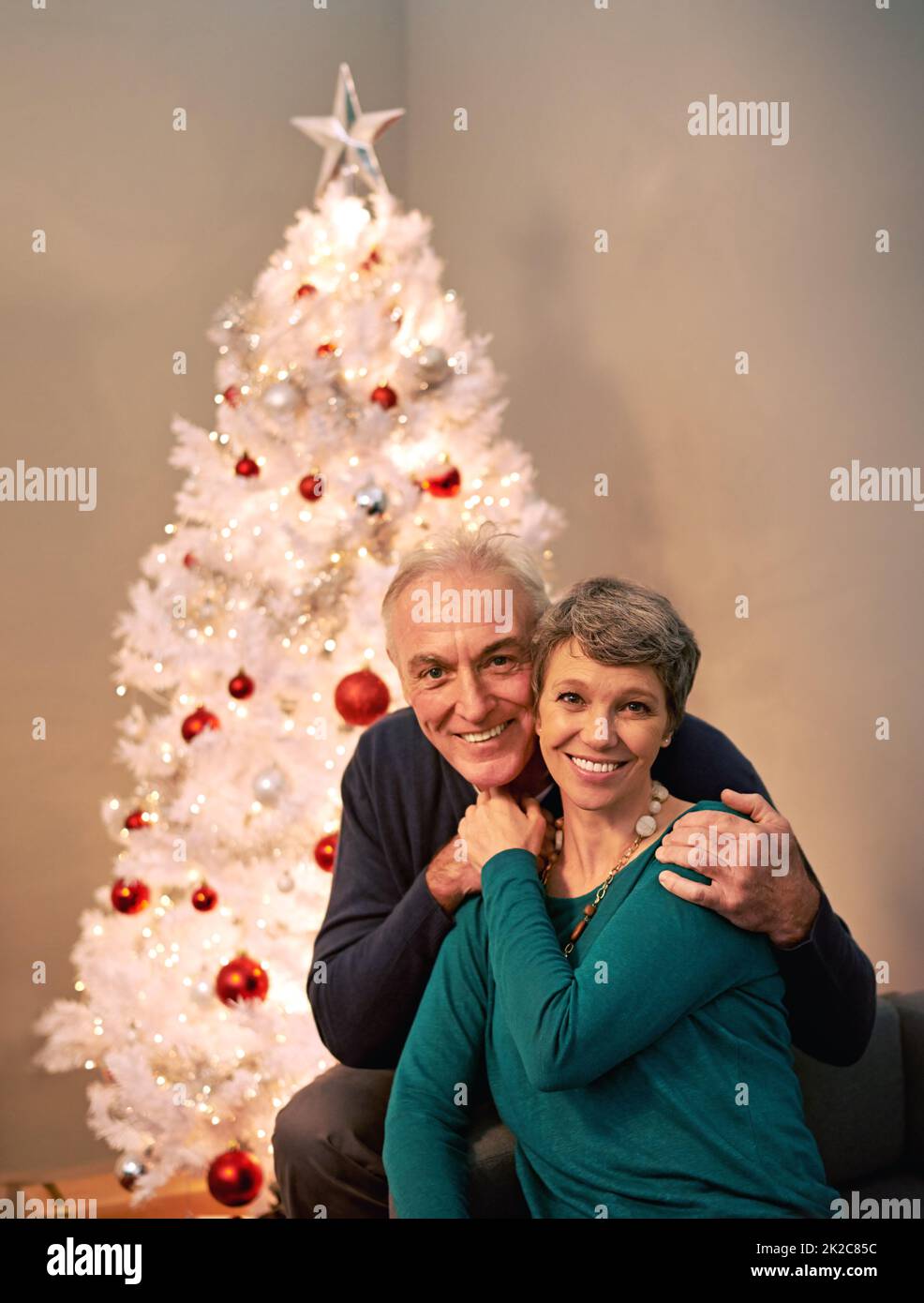 HES il regalo che chiedo a Santa per ogni Natale. Ritratto corto di una coppia matura felice accanto ad un albero di Natale. Foto Stock