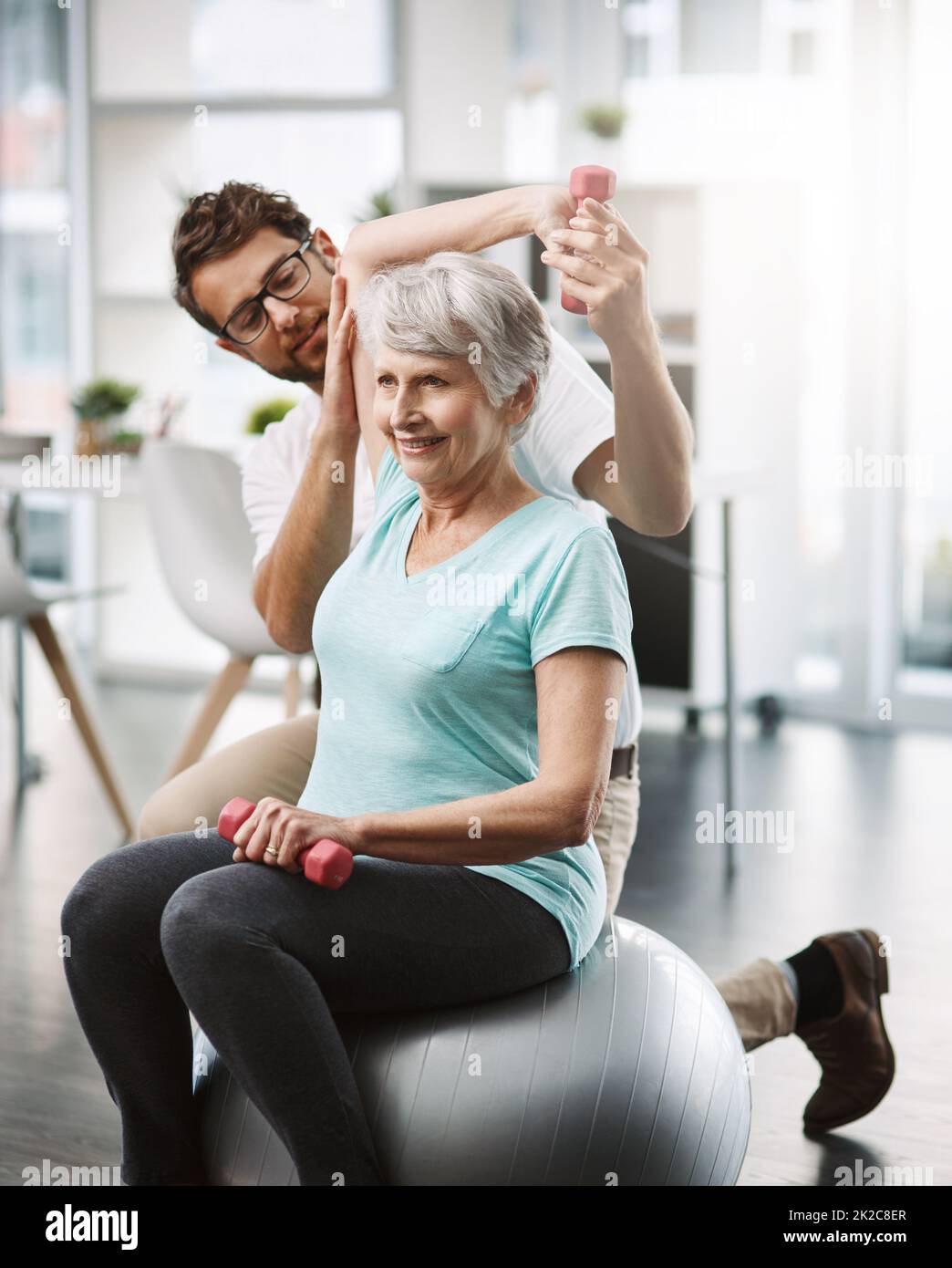 Questa spalla è forte. Scatto corto di un giovane fisioterapista maschile che lavora con una paziente femminile anziana. Foto Stock