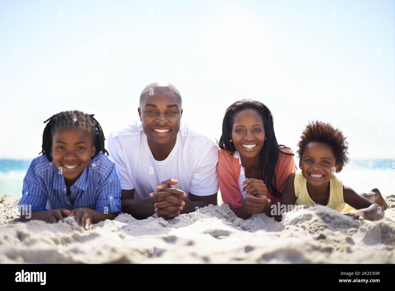 Tutti allineati per il divertimento estivo. Una famiglia afroamericana che si trova in una linea sulla spiaggia. Foto Stock