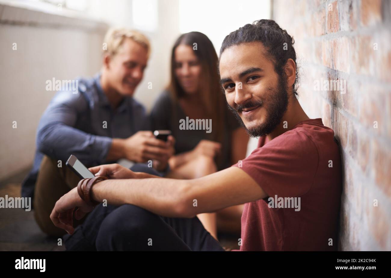 Contattare qualcuno speciale dopo la lezione. Scatto di tre studenti che si rilassano nel corridoio. Foto Stock