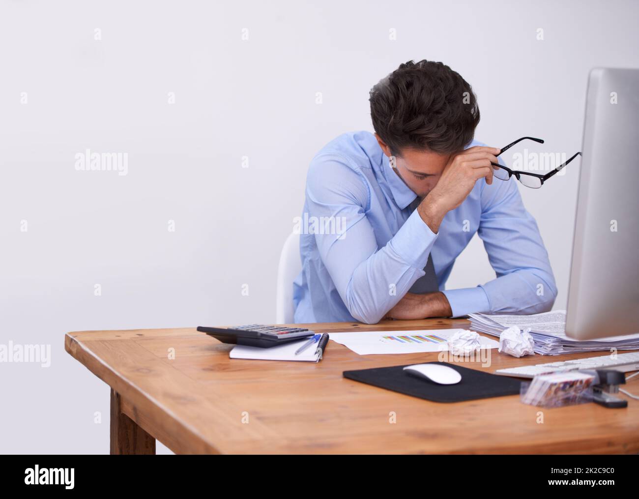 Così stanco.... Scatto corto di un giovane uomo d'affari stanco-osservante seduto nel suo ufficio. Foto Stock