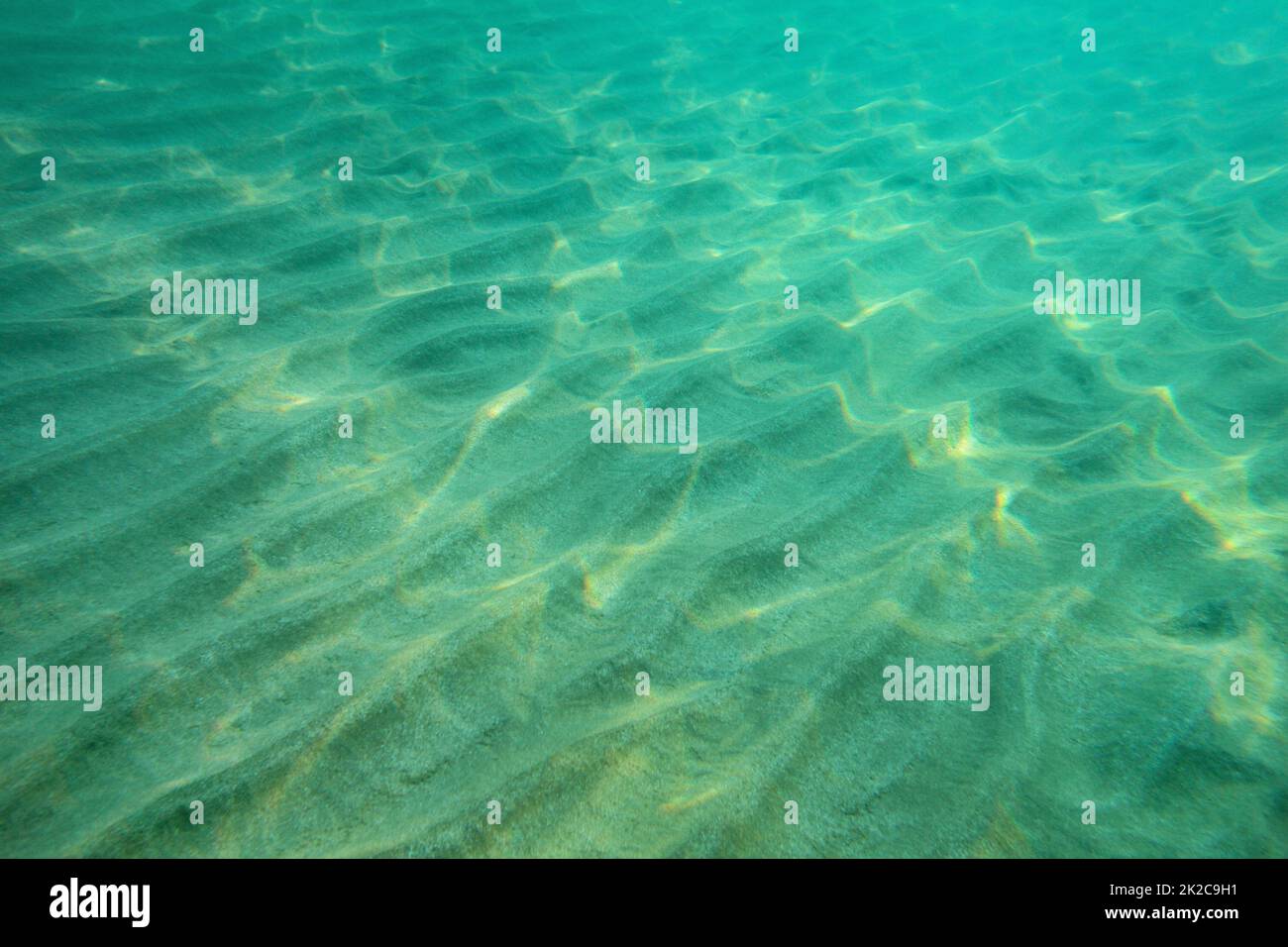 Oceano pavimento foto subacquee, sabbia 'dunes' illuminata dalla luce del sole. Abstract sfondo marino. Foto Stock