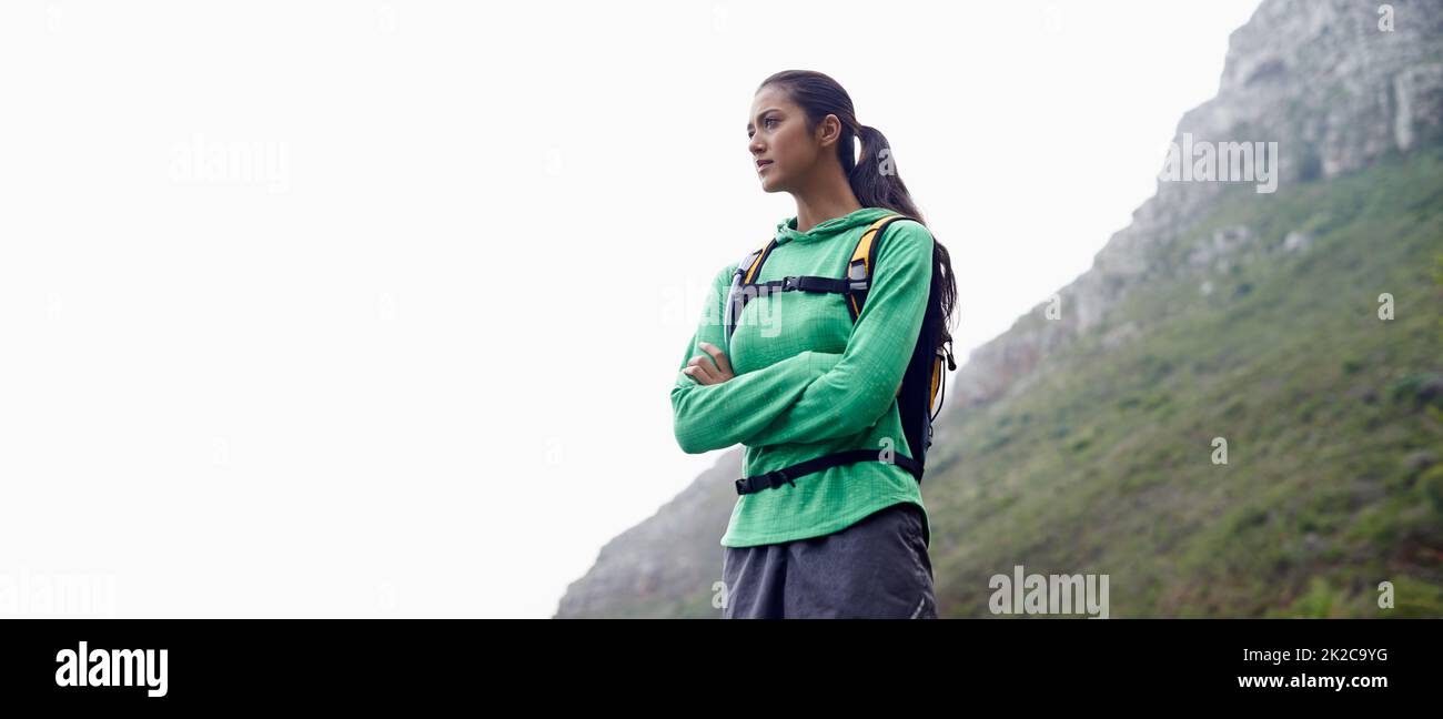 Ama correre. Una bella giovane donna in piedi sullo sfondo di montagne panoramiche che stanno per andare a fare un'escursione. Foto Stock