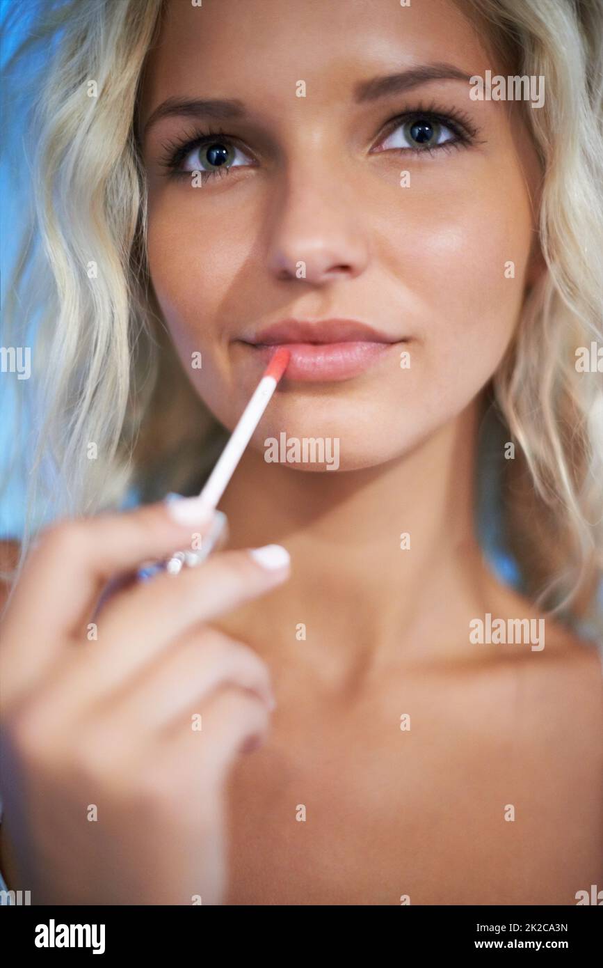 Pout perfetto. Bella giovane donna che mette su un po 'di lucentezza. Foto Stock