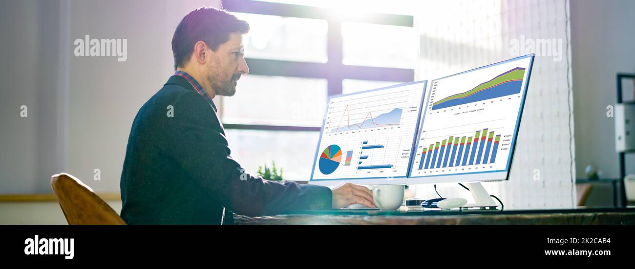 Man Advisor che utilizza più monitor per computer Foto Stock