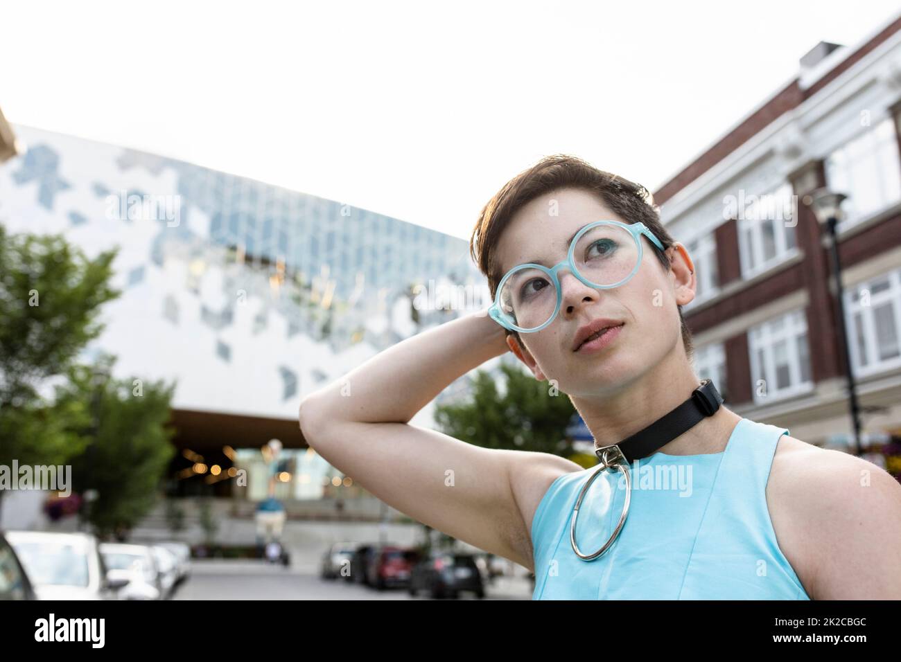 Ritratto elegante non-binary giovane adulto con capelli corti e occhiali Foto Stock
