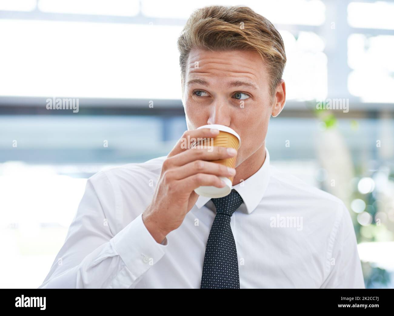 Tempo per una pausa caffè. Un giovane uomo d'affari che beve una tazza di caffè. Foto Stock