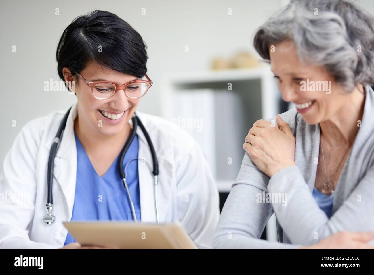 La vostra salute sta migliorando enormemente. Scatto ritagliato di un medico e di un paziente che guarda insieme alcune cartelle cliniche. Foto Stock