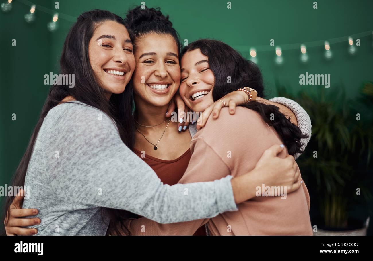 Erano come una famiglia di amici. Foto di tre giovani sorelle felici che si abbracciano in un bar. Foto Stock