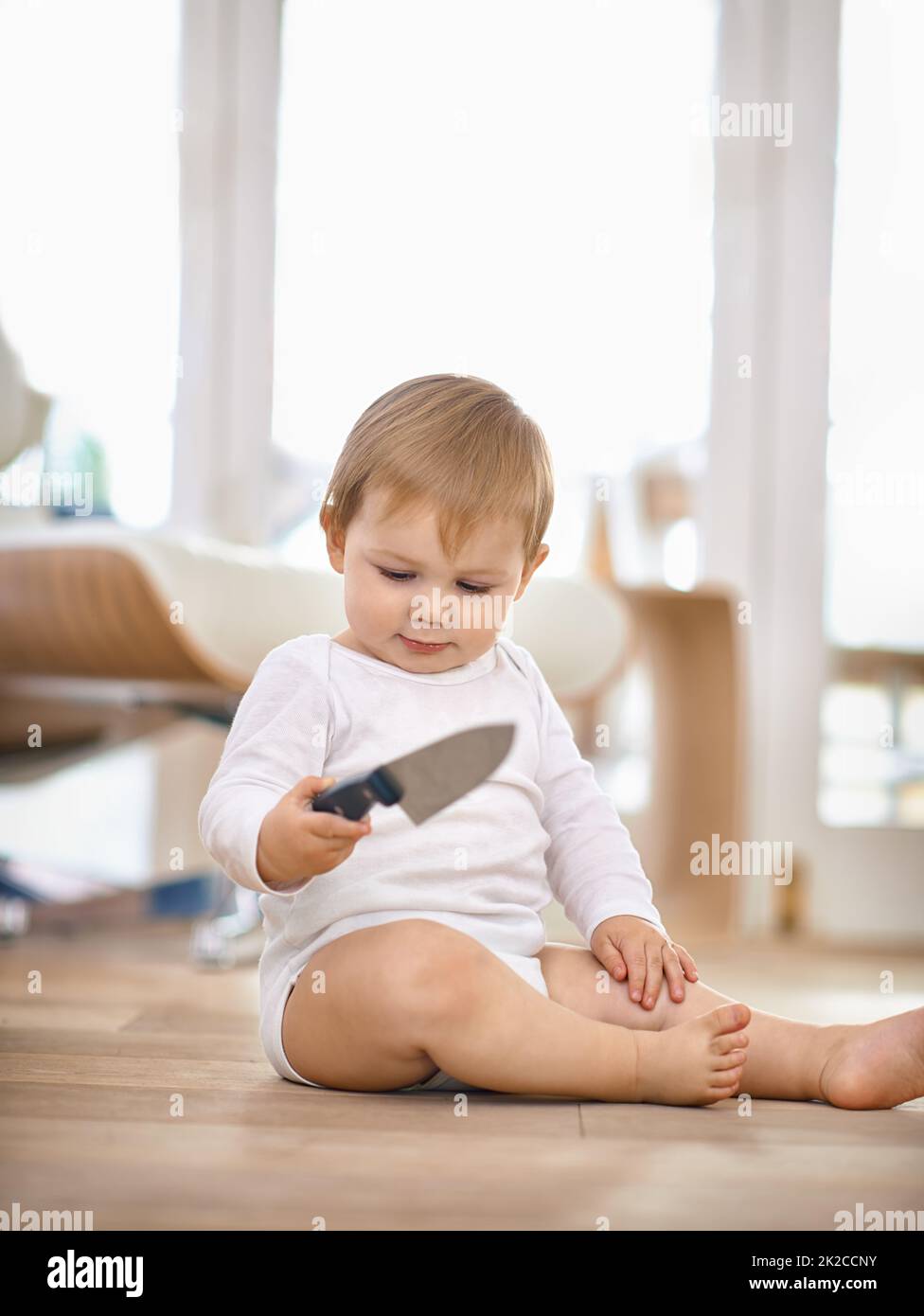 Lascia i tuoi figli da soli per soli 10 secondi e il roba accade.. Shot di un ragazzo giovane che tiene un coltello da cucina. Foto Stock