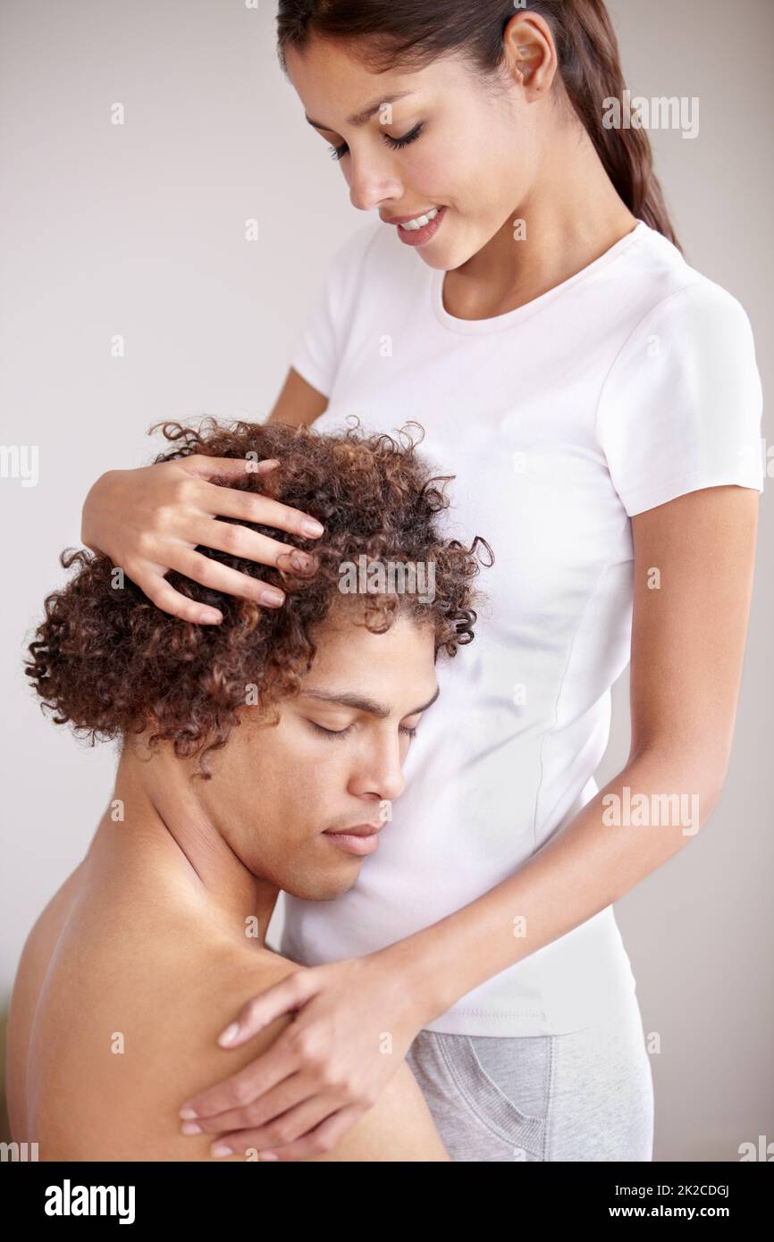HES l'unico per me. Una giovane coppia etnica tenendosi dolcemente con la testa di mans poggiata sullo stomaco dei coniugi. Foto Stock