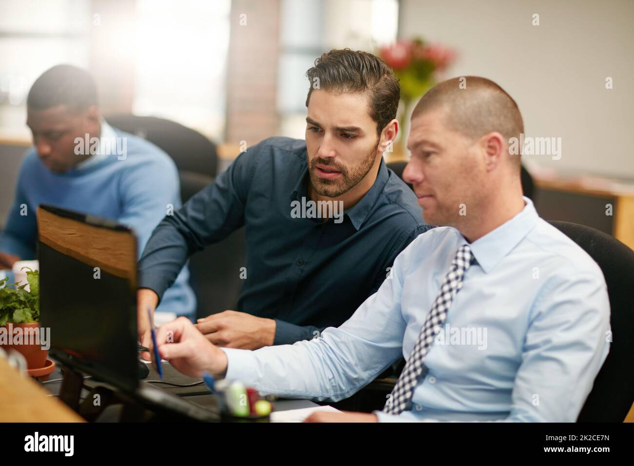 HES sempre disponibile ad aiutare. Scatto ritagliato di tre uomini d'affari che lavorano in ufficio. Foto Stock