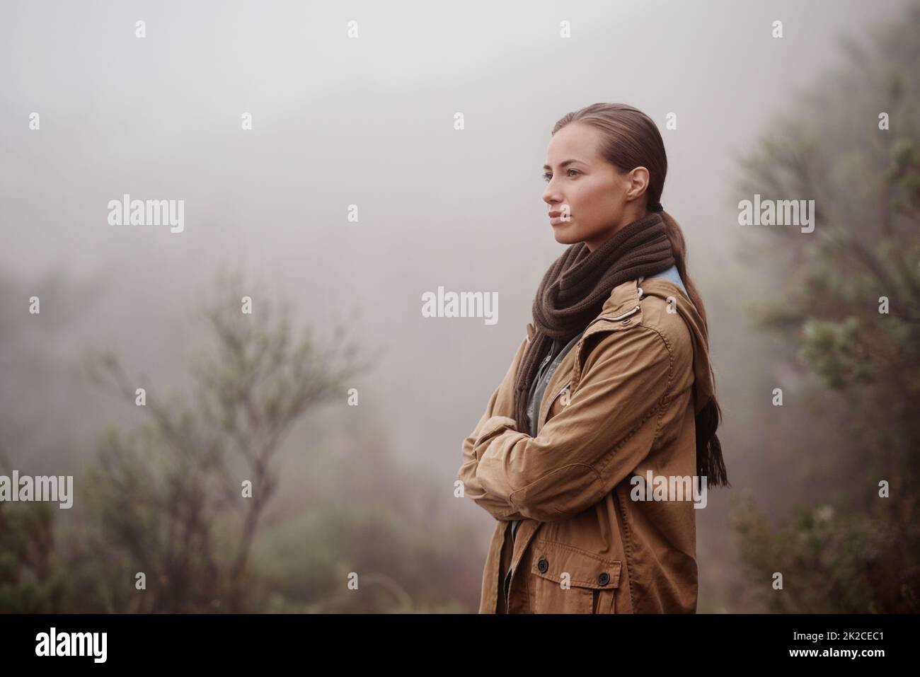 Musiche nella nebbia. Una giovane donna attraente fuori per una passeggiata in montagna. Foto Stock