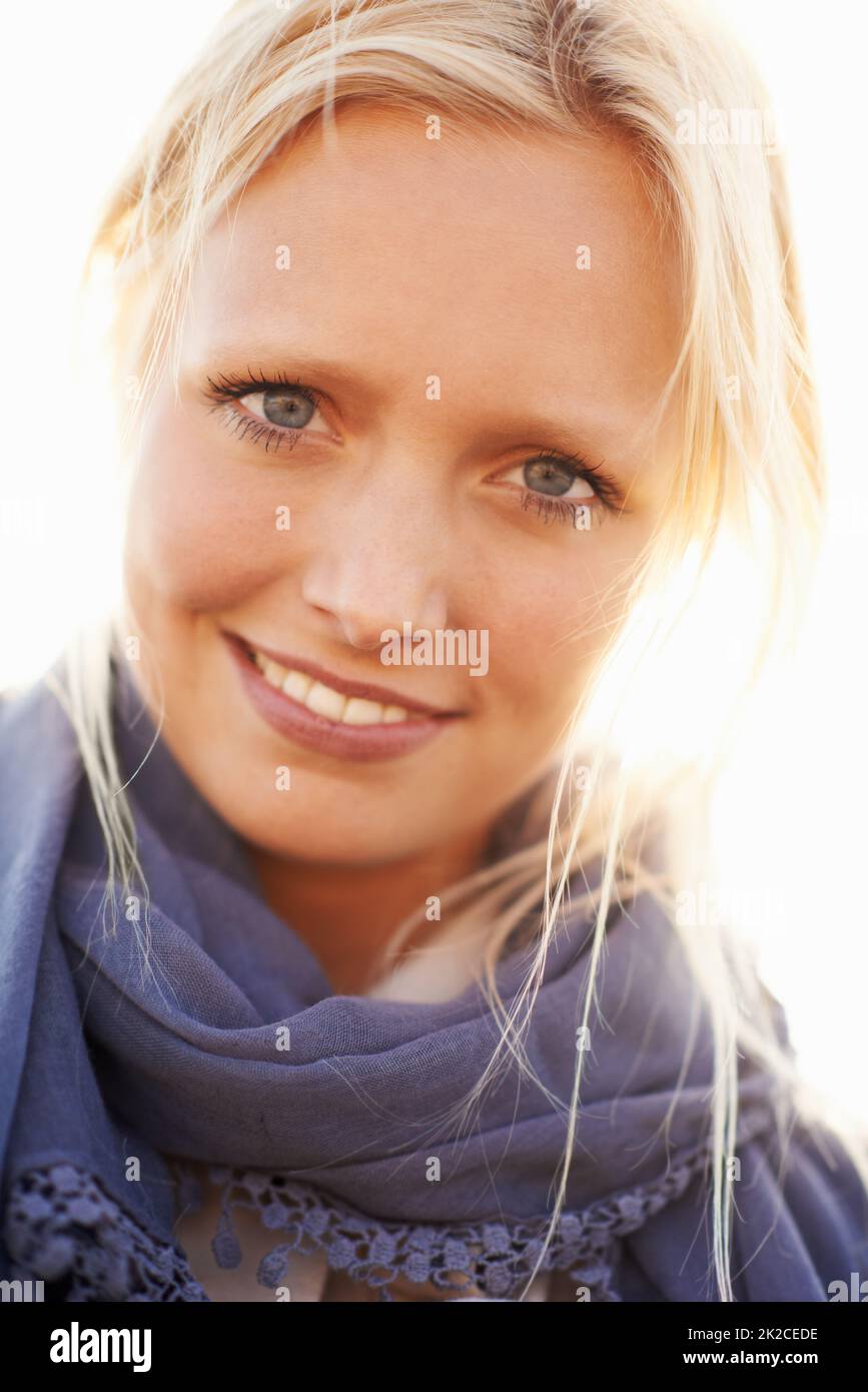 Bellezza estiva senza tempo. Una bella giovane donna sorridente contro la luce del sole. Foto Stock