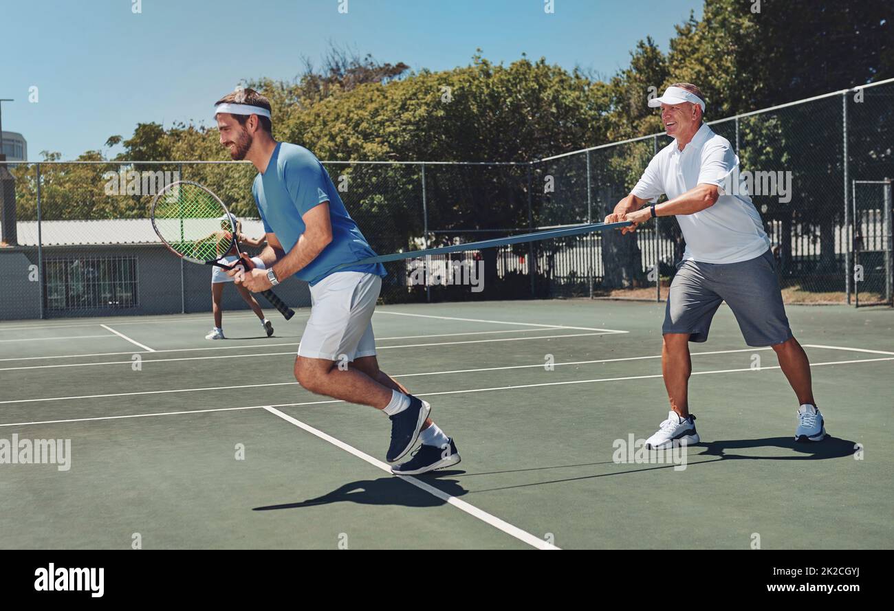 Costruire quella forza. Scatto completo di due bei sportivi che usano bande resistenti durante una sessione di allenamento di tennis durante il giorno. Foto Stock