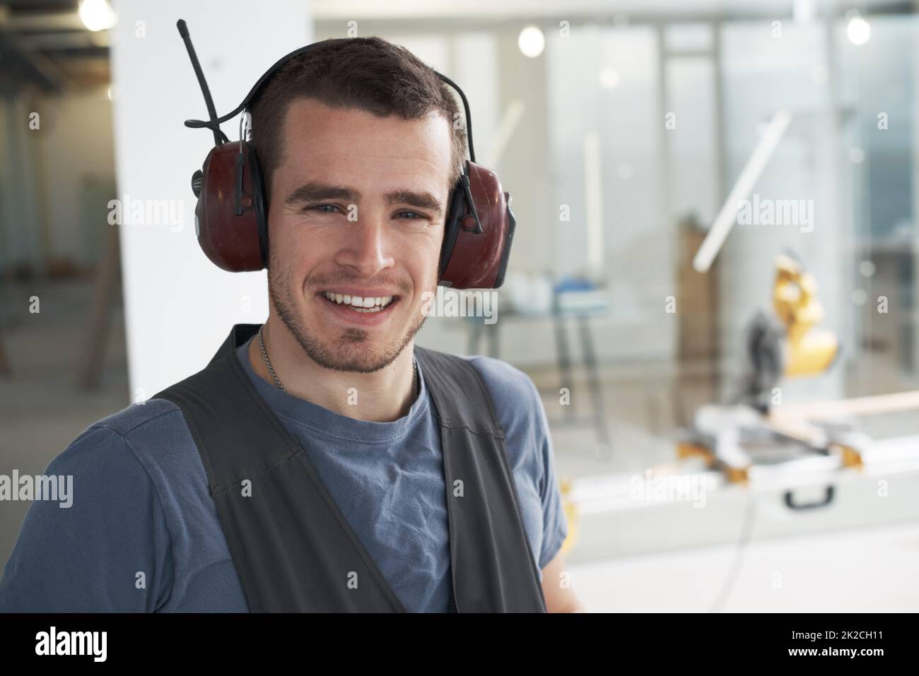 HES si è impegnata in un grande lavoro di appalto. Bel giovane appaltatore in piedi su un cantiere. Foto Stock