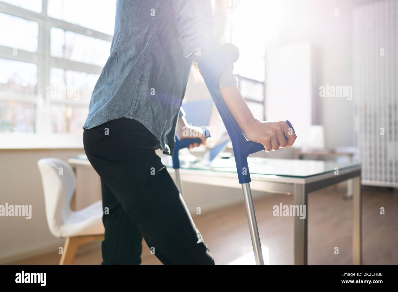 Lavoratore con stampelle sul luogo di lavoro o ufficio Foto Stock