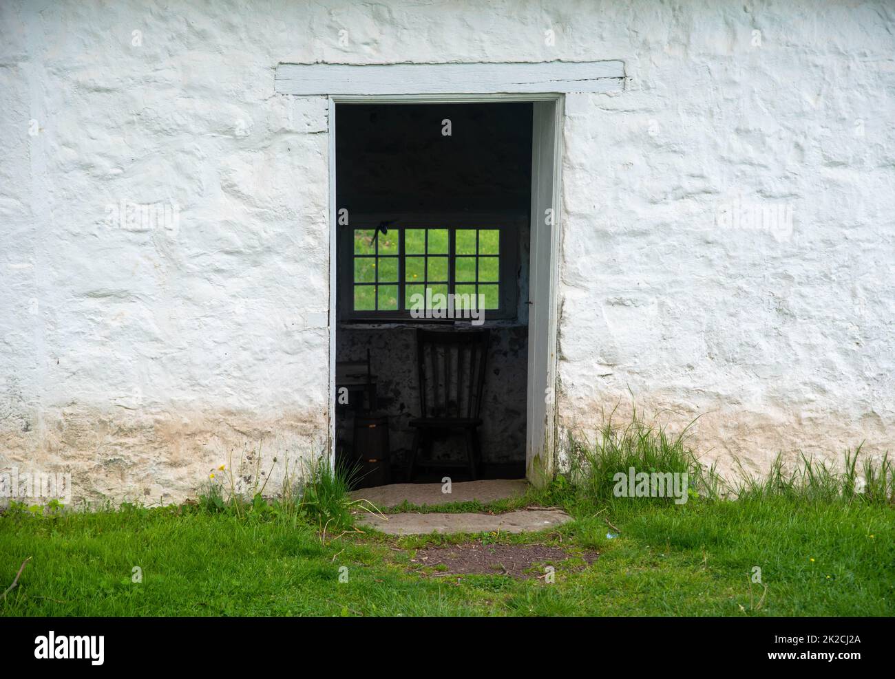 Vista attraverso la porta aperta in pietra coloniale americana springhouse Foto Stock