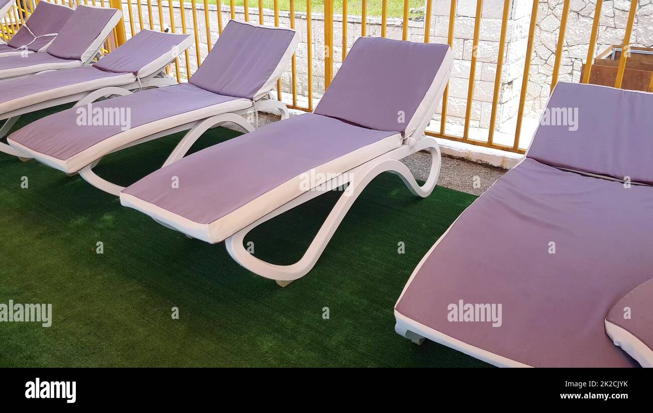 sedie a sdraio vuote si trovano in fila sotto il tetto del solarium per prendere i bagni d'aria sulla riva del mare, una località turistica Foto Stock