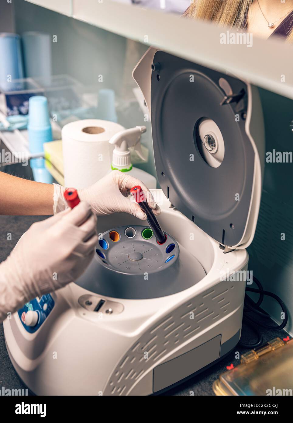 L'infermiere ha inserito il campione di sangue nella centrifuga da laboratorio Foto Stock