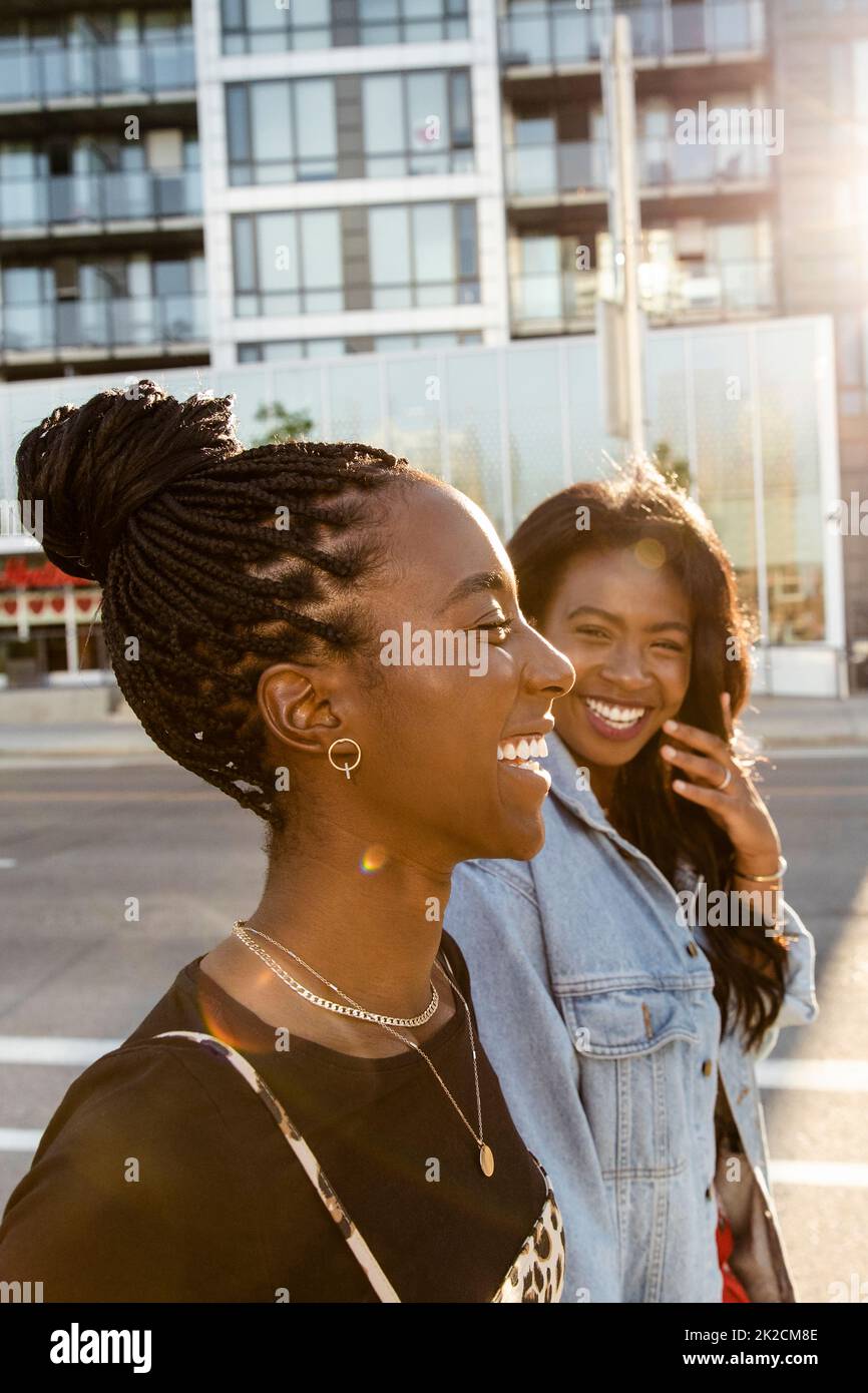 Felici giovani donne amici ridendo in città strada Foto Stock