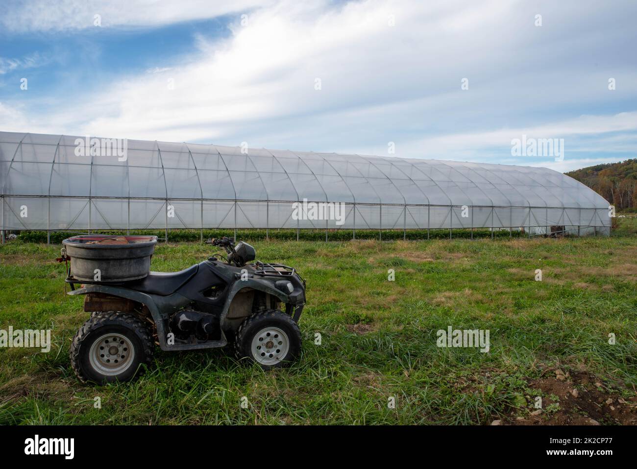 Lunga casa verde in un campo agricolo con veicolo fuoristrada Foto Stock