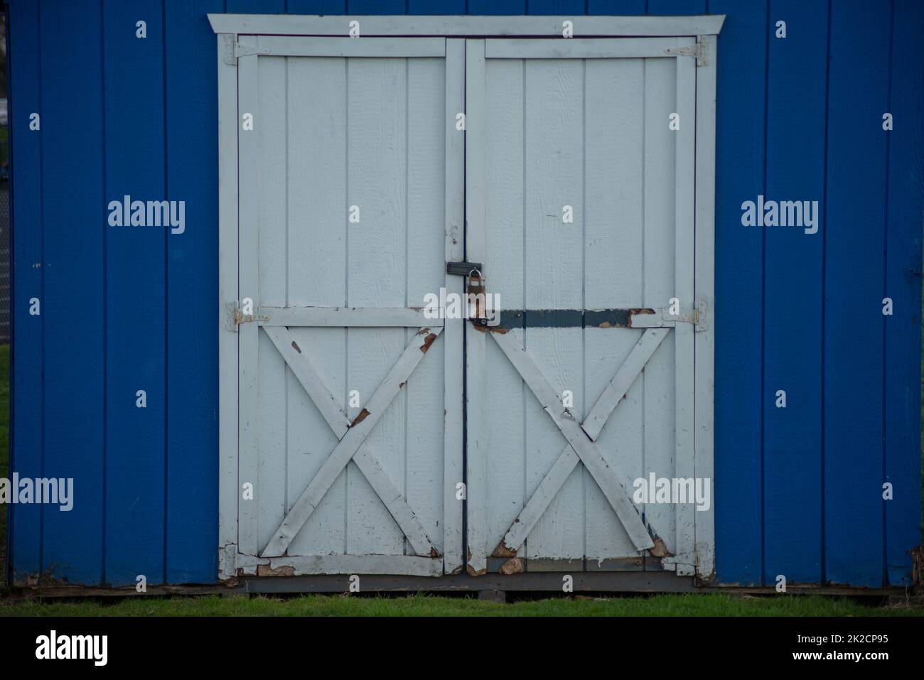 Capannone esterno in legno blu rustico doppio bianco porte chiuse Foto Stock