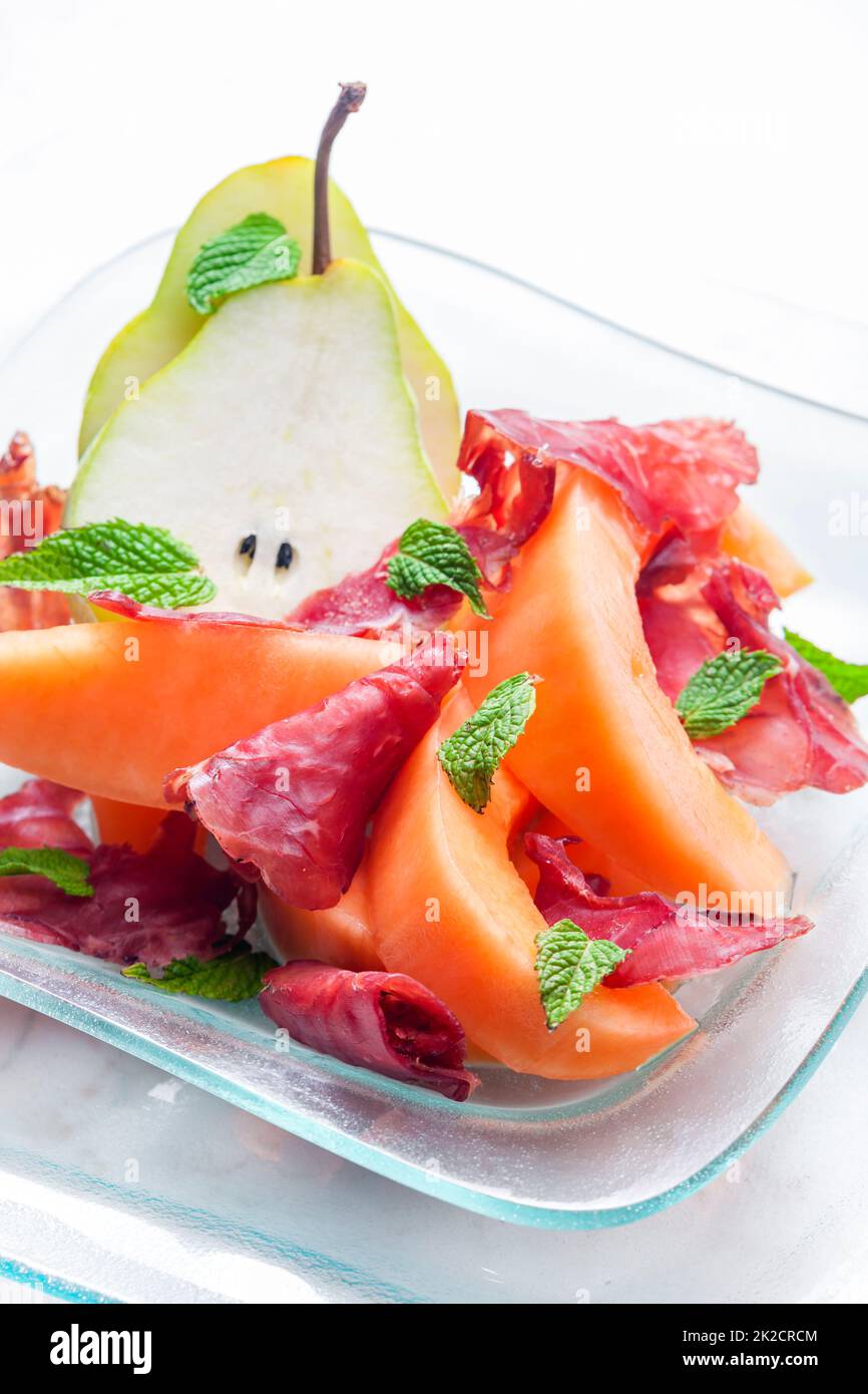 melone cantalupo e pera con foglie di proscutto e menta Foto Stock