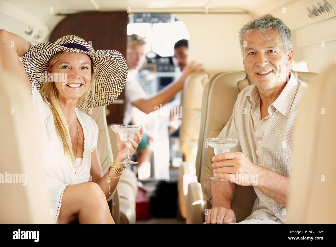 Volare con stile. Shot di una coppia matura seduta sul retro di un jet cocktail privato. Foto Stock
