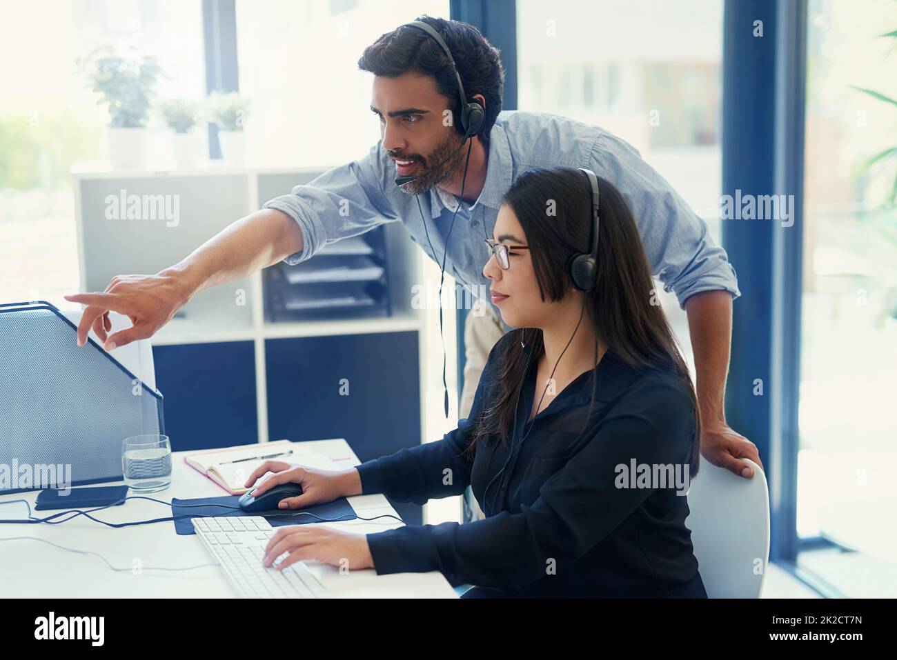 Formazione di un nuovo dipendente sulla fornitura di un servizio di qualità. Scatto ritagliato di due agenti di call center che lavorano insieme in un ufficio. Foto Stock