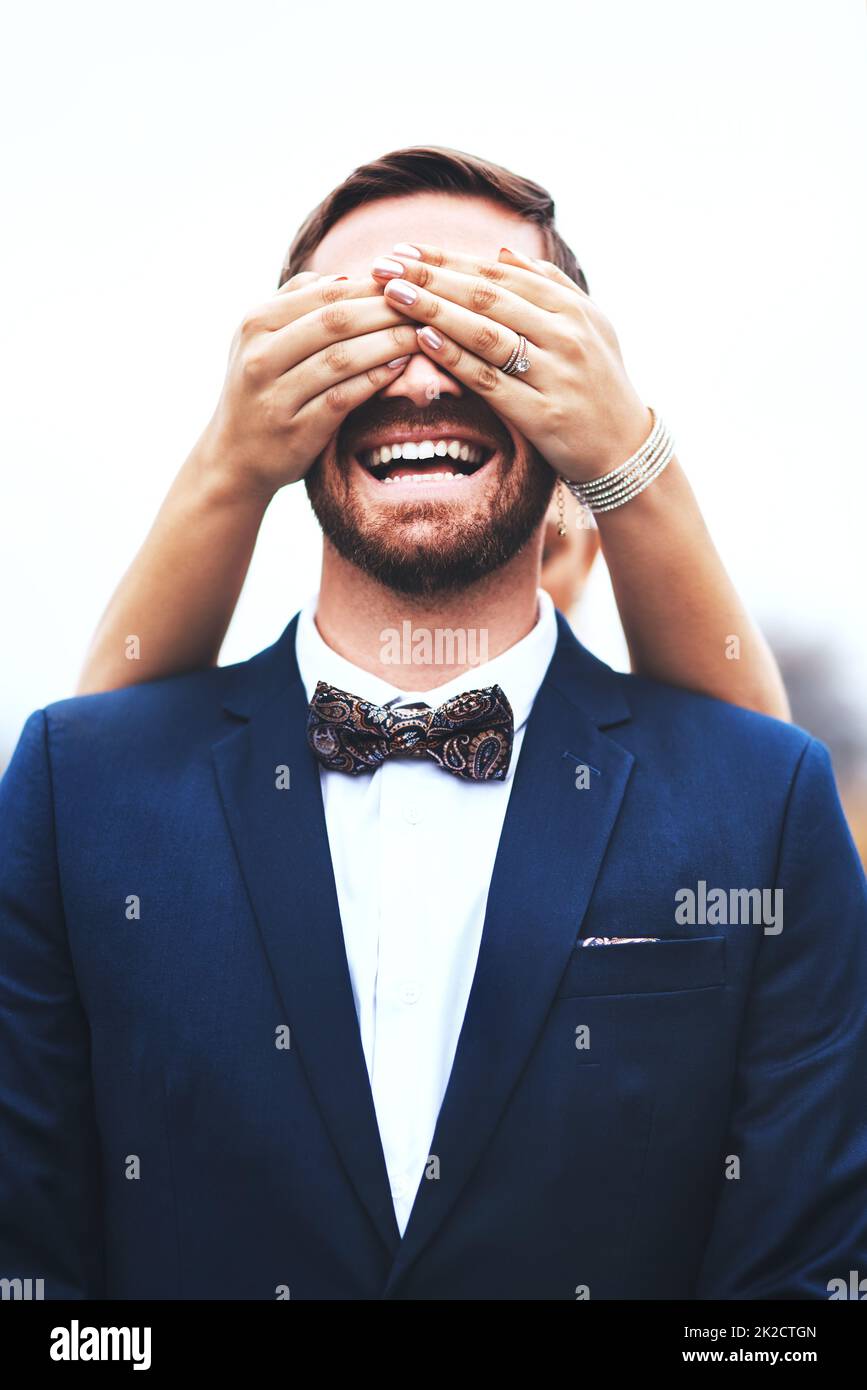 Vedo solo momenti di divertimento avanti con te il mio amore. Scatto di uno sposo felice che ottiene i suoi occhi coperti dalla sua sposa il loro giorno di nozze. Foto Stock