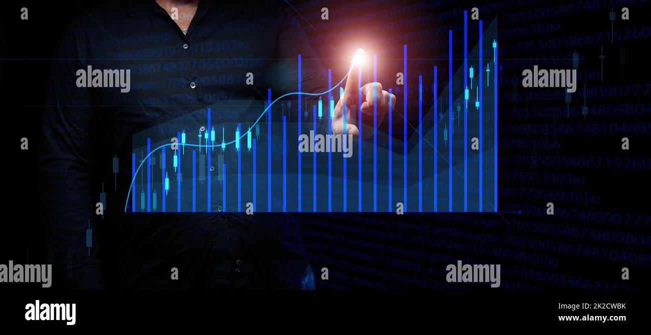 l'uomo d'affari in un vestito si leva davanti ad un grafico olografico con le figure crescenti, la crescita di affari, reddito alto. Negoziazione in borsa Foto Stock