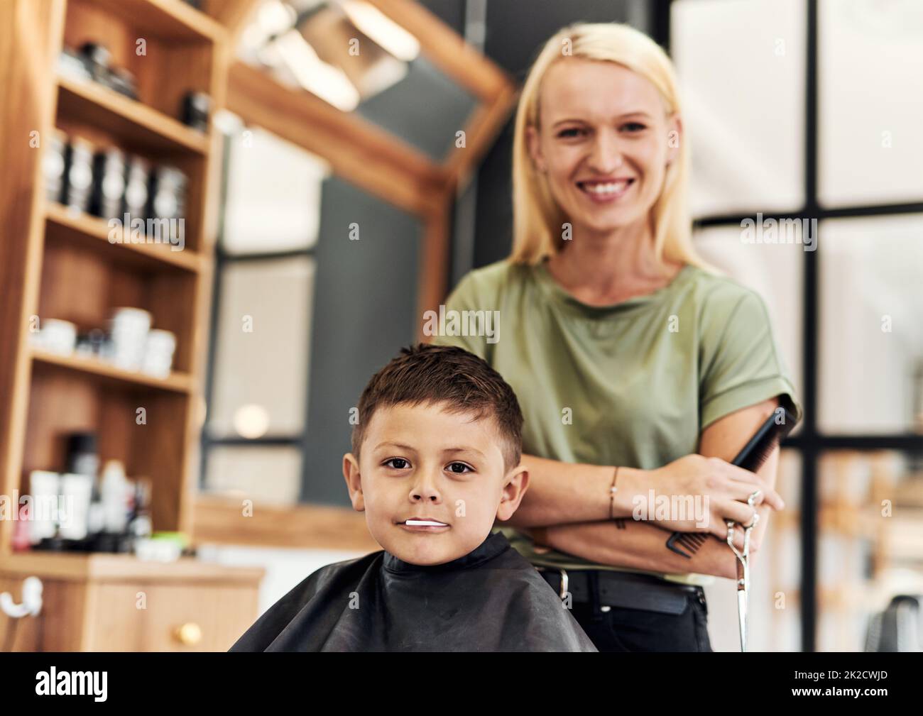 Andò per il suo primo taglio ufficiale di capelli oggi. Ritratto di un ragazzo adorabile che ottiene un taglio di capelli ad un salone. Foto Stock