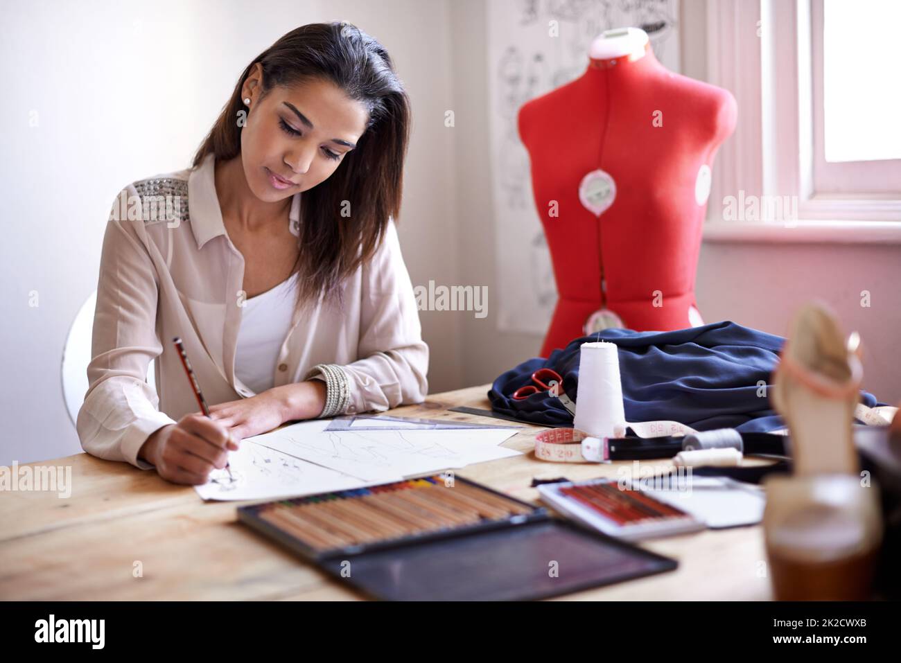 Creare le tendenze di questa stagione. Un fashion designer che crea schizzi nel suo ufficio. Foto Stock